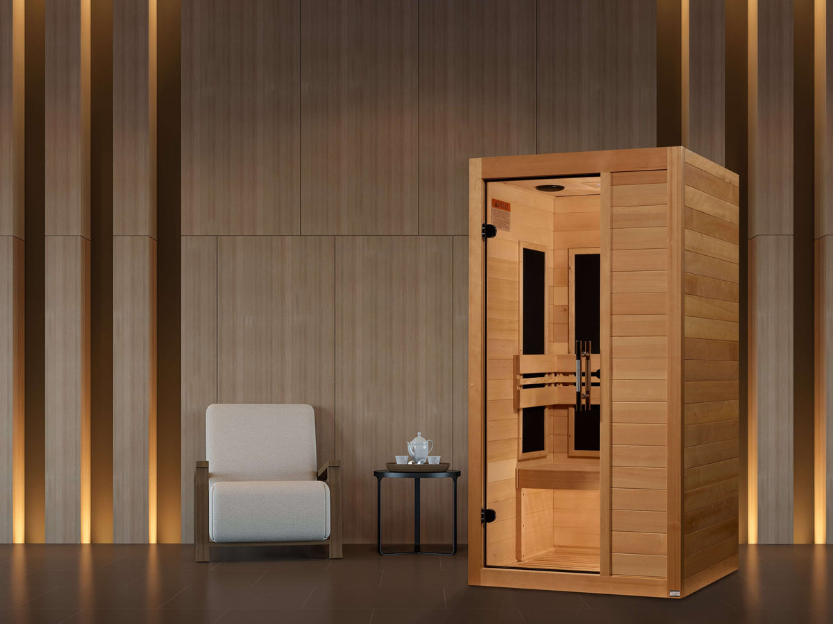 Maxxus S-Line Yoga 1-Person Low EMF FAR Infrared Sauna (Canadian Hemlock) Indoor home sauna placed in a living space next to a table and chair, designed for daily relaxation and wellness