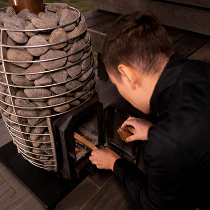 HUUM HIVE Wood 17 wood-burning sauna stove being loaded